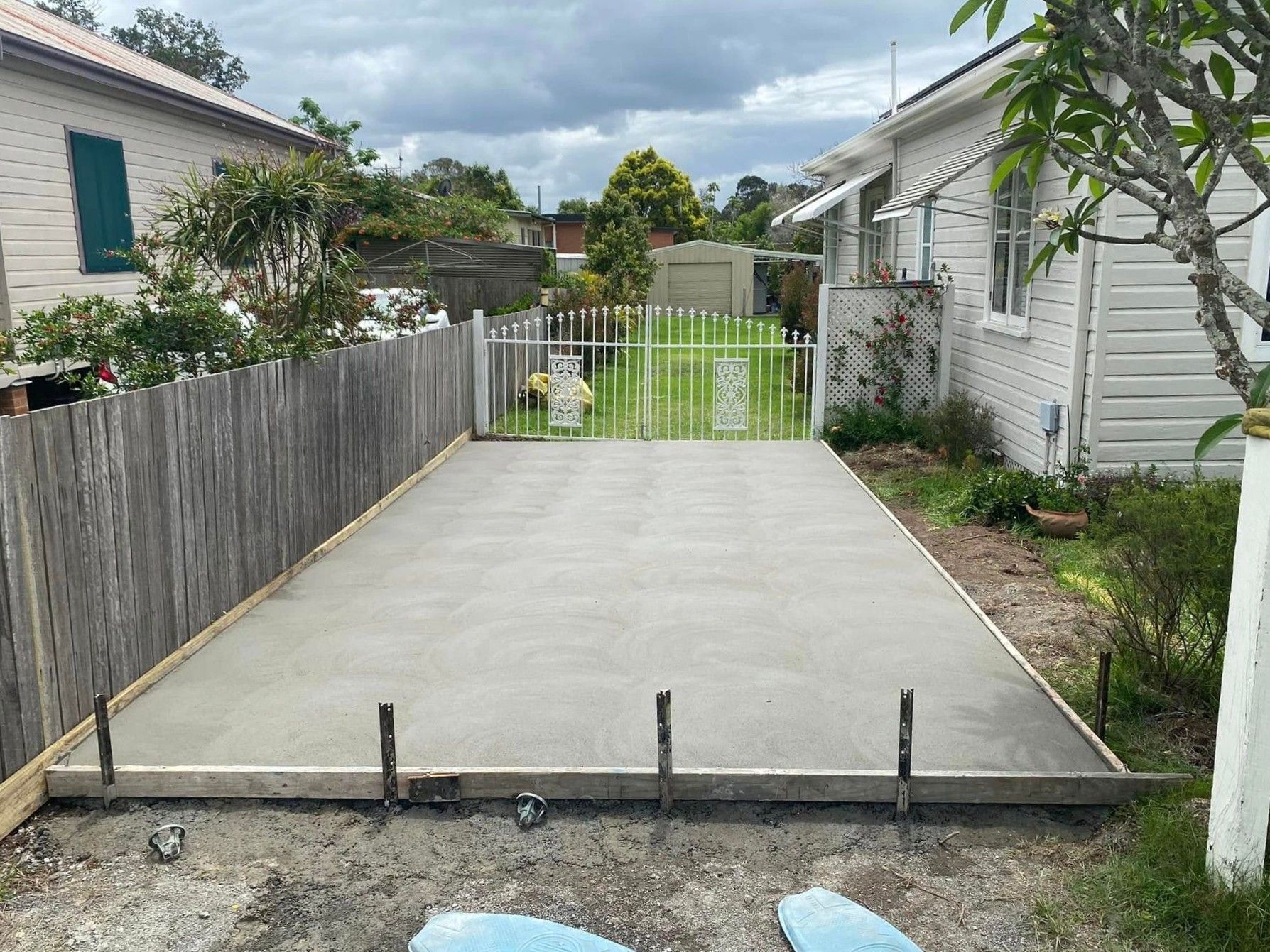 Freshly Poured Concrete Slab Bordered by Wood, in a Residential Yard — Rhyno’s Concreting In Old Bar, NSW