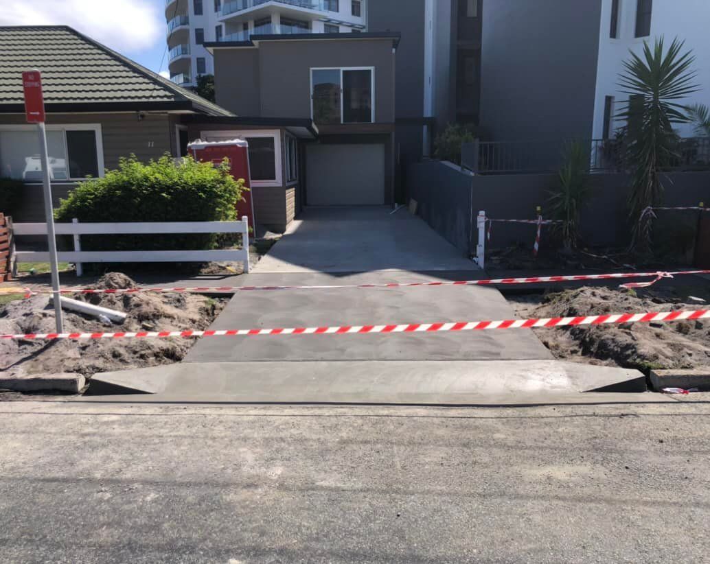 Newly Poured Concrete Driveway With Red/white Tape, in Front of a House — Rhyno’s Concreting In Old Bar, NSW