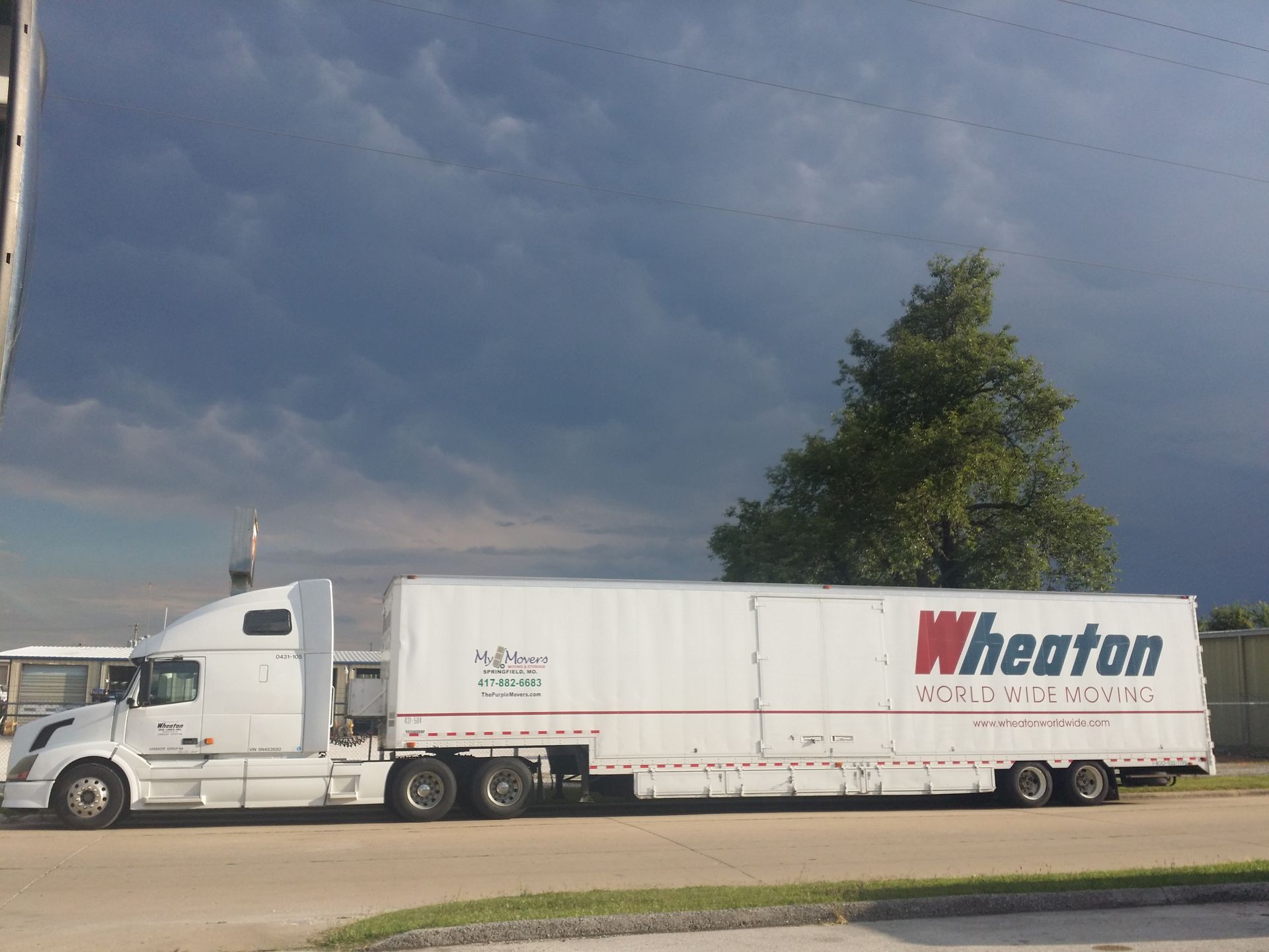 White Wheaton moving truck parked under a cloudy sky
