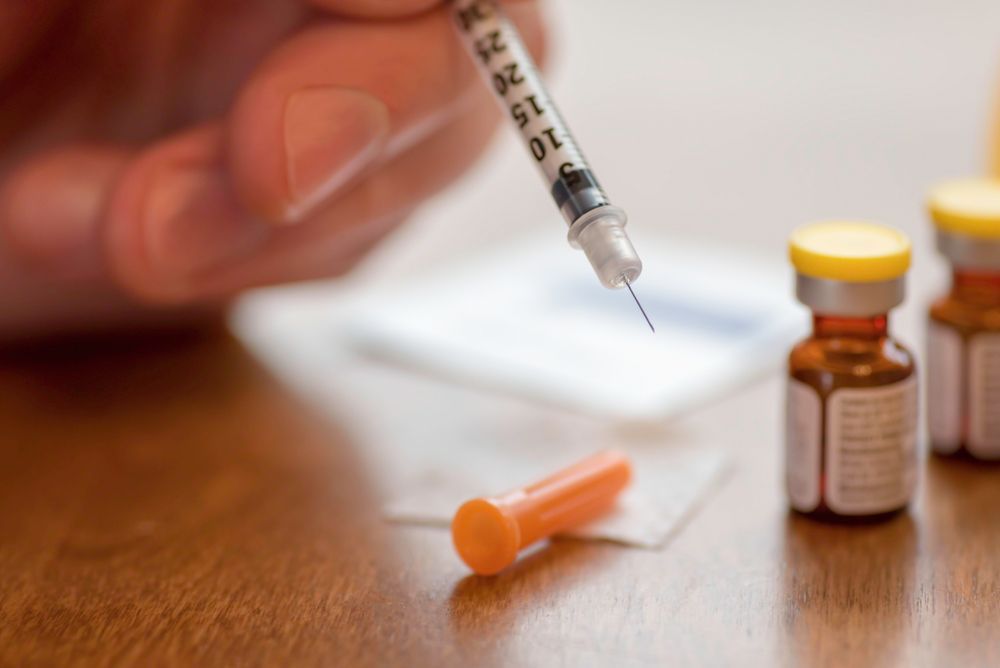 A person is holding a syringe with the number 10 on it