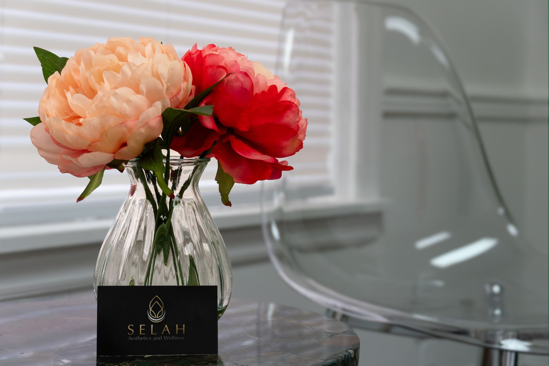 A vase of flowers sits on a table next to a selah business card
