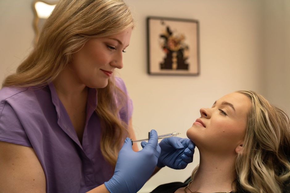 A woman is getting a botox injection in her face.