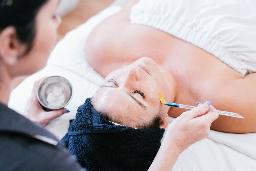 A woman is getting a facial treatment at a spa.