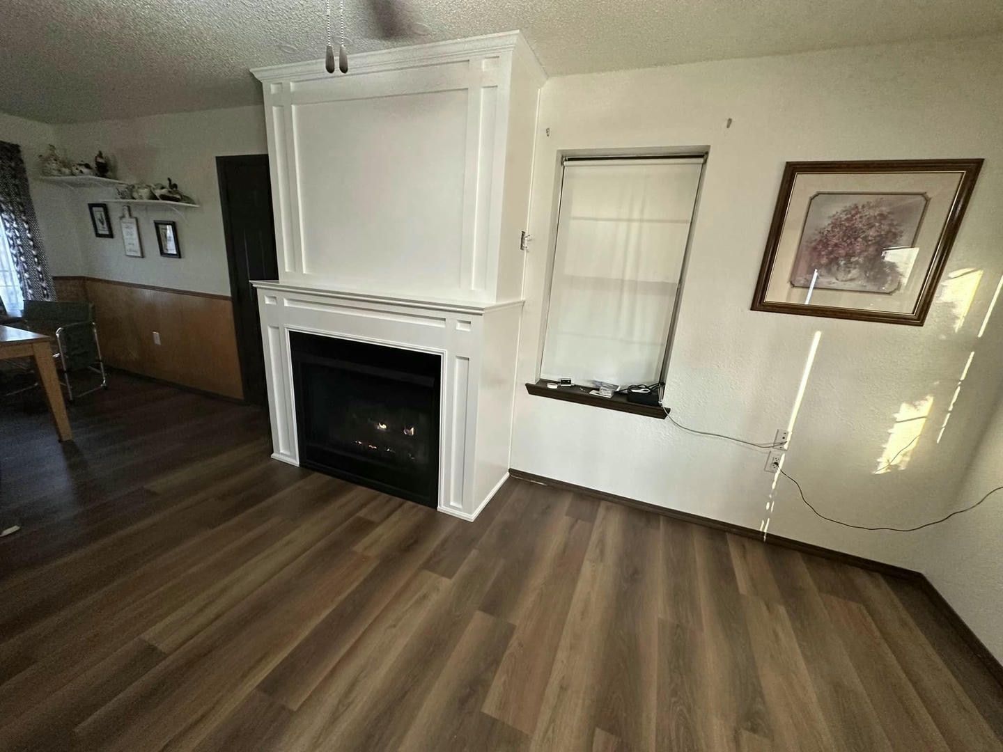 A living room with hardwood floors and a fireplace