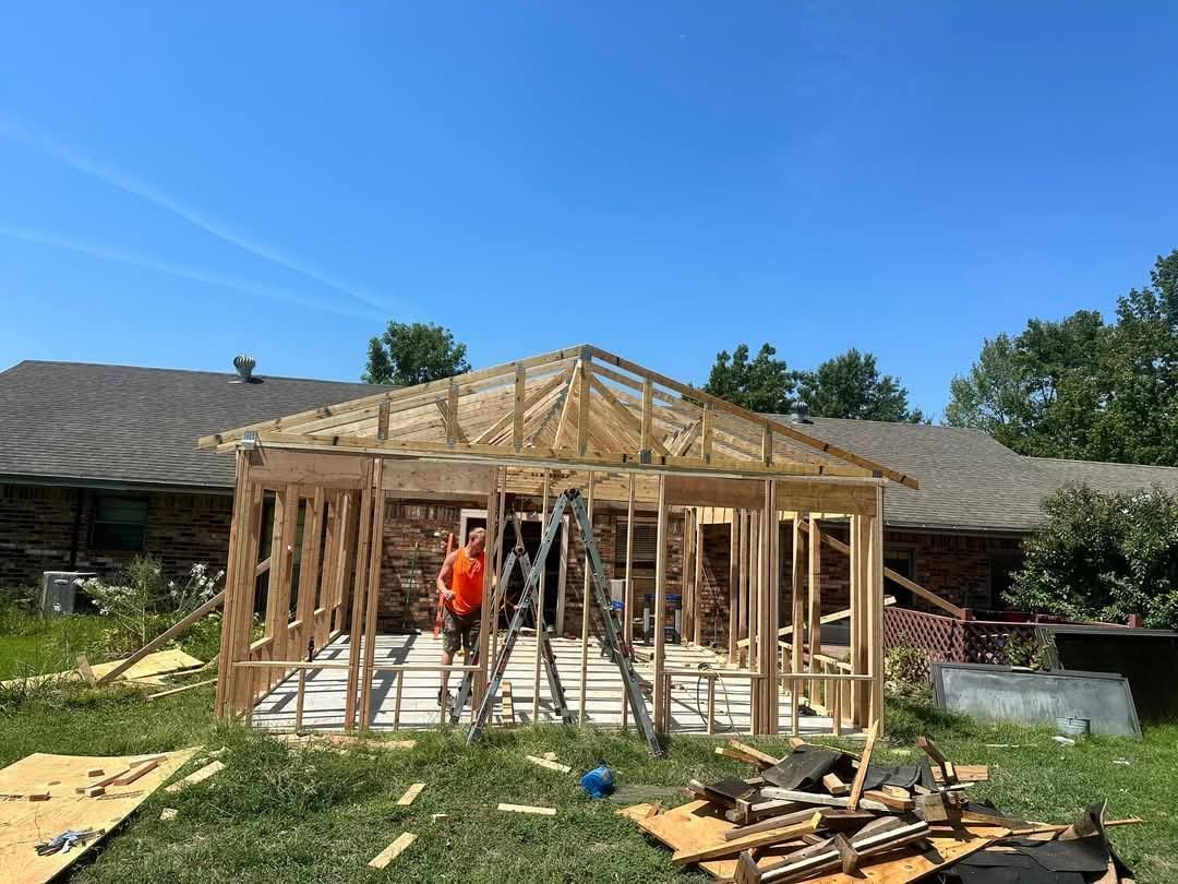 A man is standing in front of a house being built.