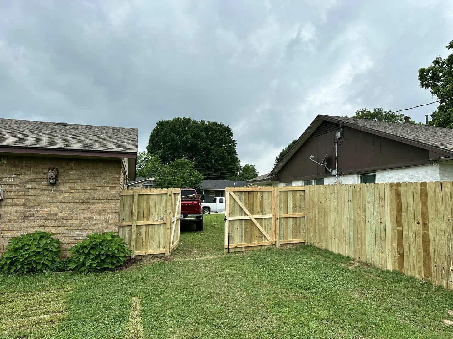 A wooden fence is being built in front of a house.