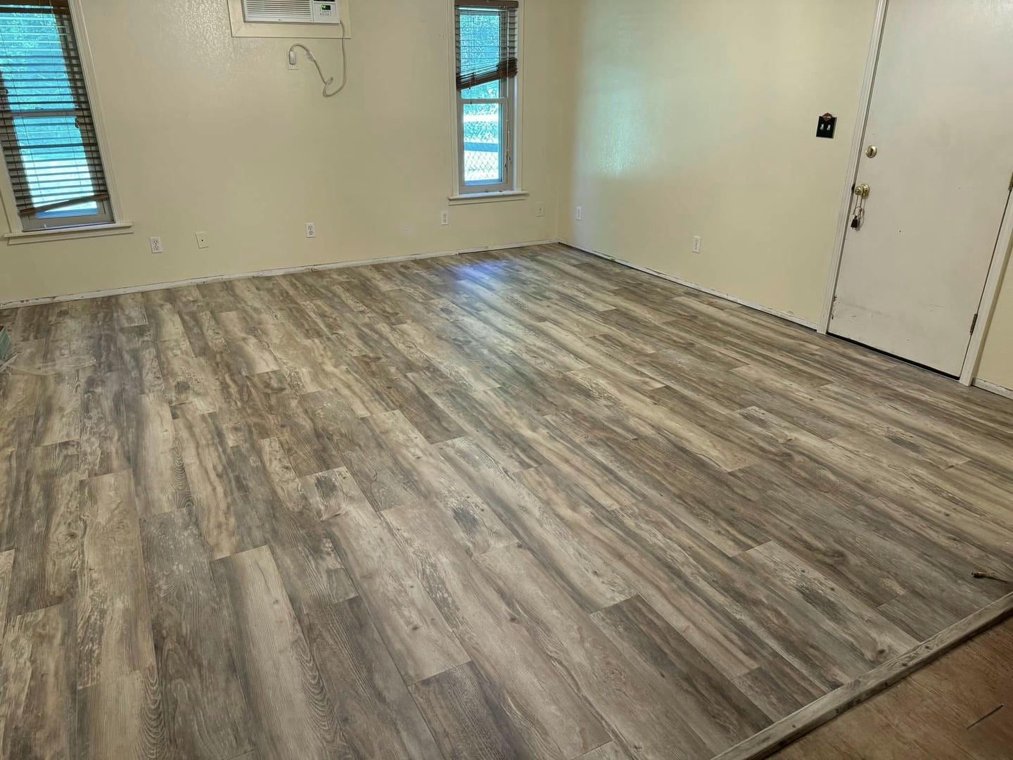 A room with a wooden floor and a door.