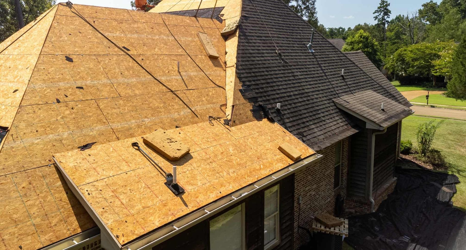An aerial view of a house with a roof that is being repaired.