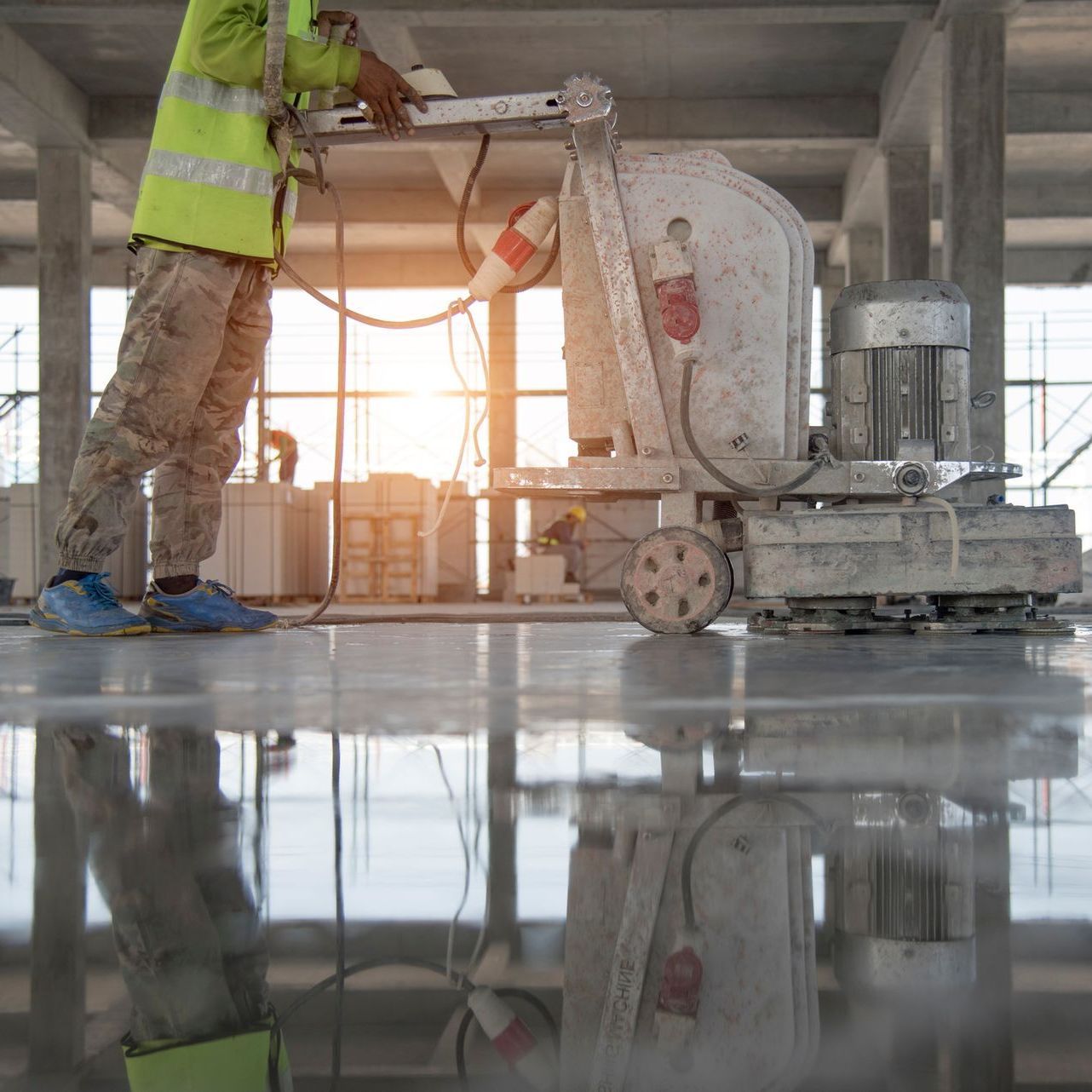 Un uomo sta usando una macchina per lucidare un pavimento di cemento.