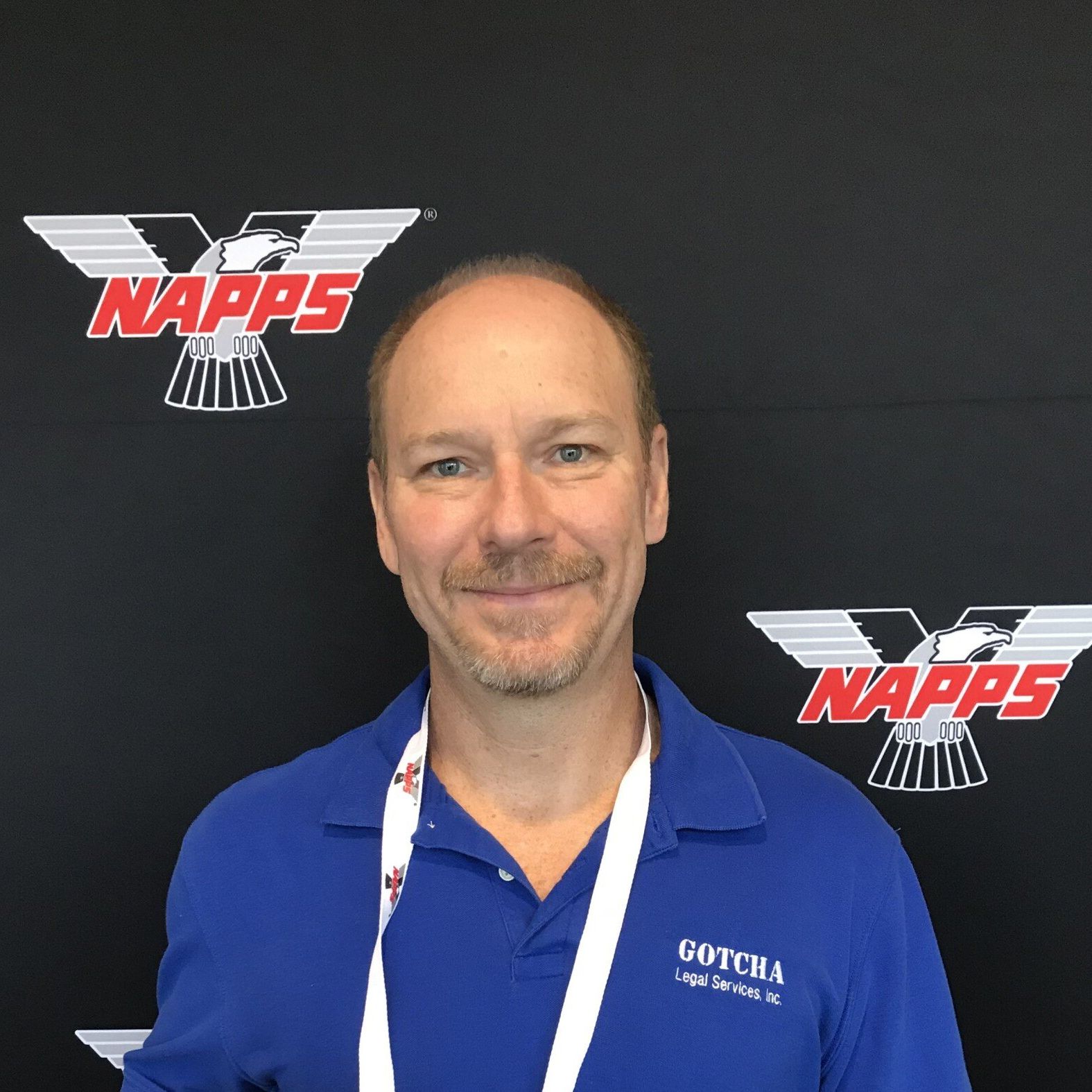 A man wearing a blue shirt with the word napps on it