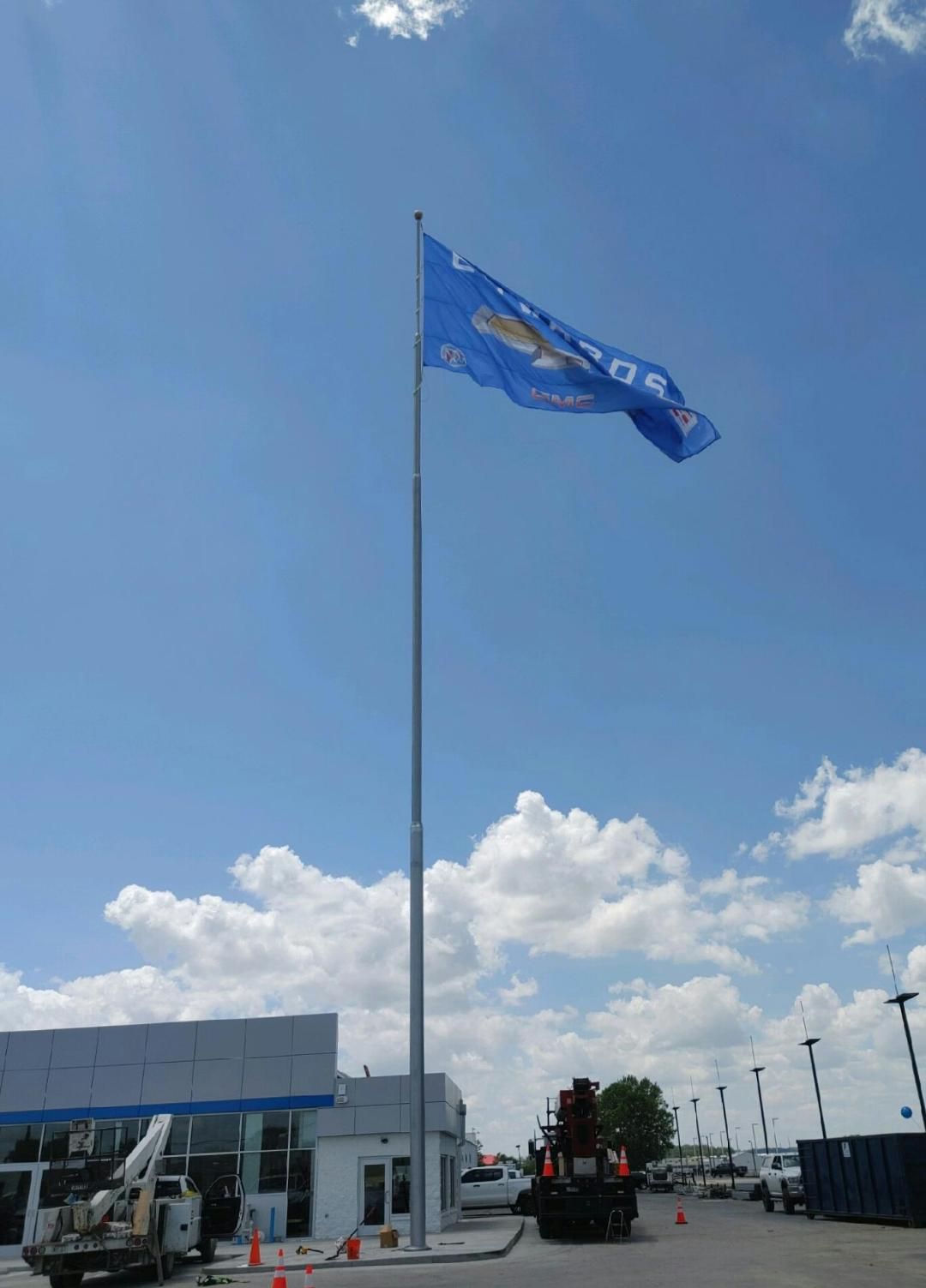A large blue flag is flying in front of a building