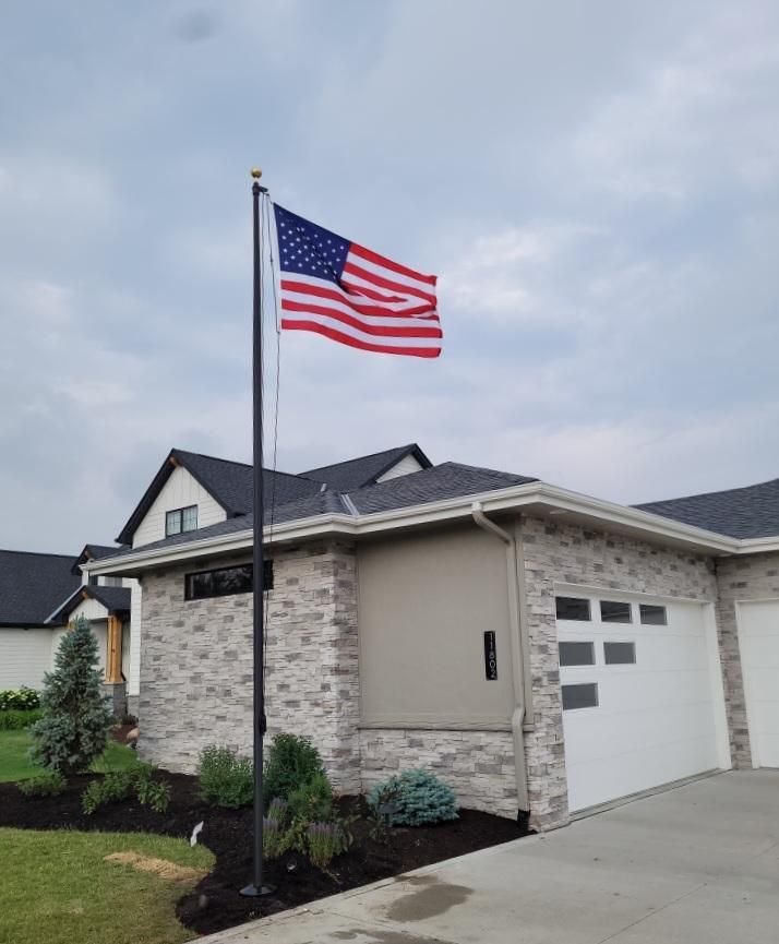 An american flag is flying in front of a house.