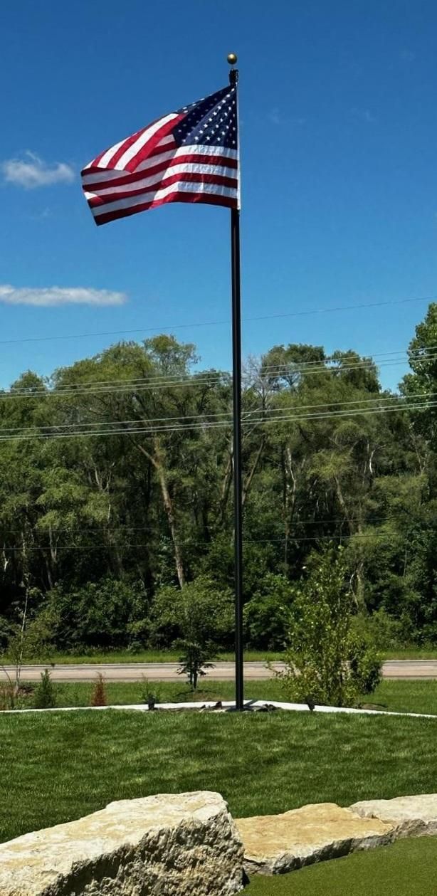 An american flag is flying in the wind on a pole