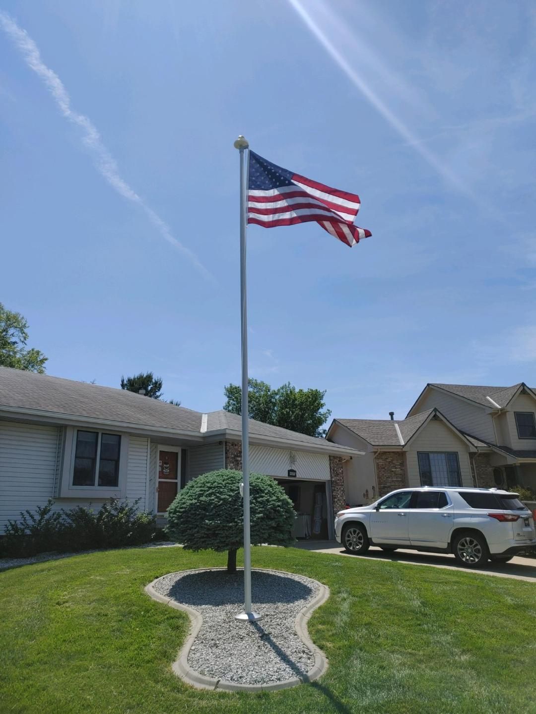 An american flag is flying in front of a house.
