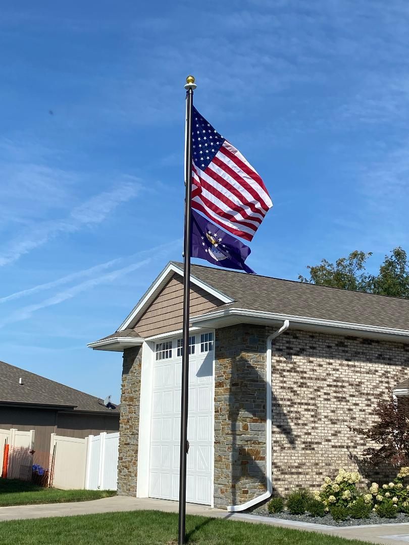 25 Bronze Flag Pole With Bricked House — Omaha, NE — A -1 Flags, Poles, and Repair