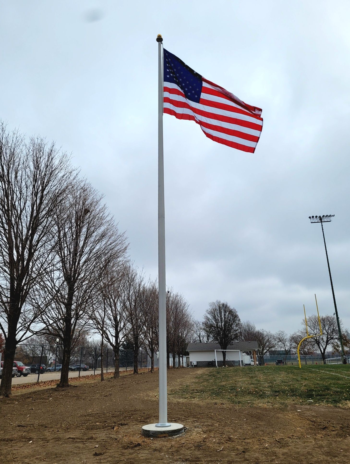 An american flag is flying on a pole in a field