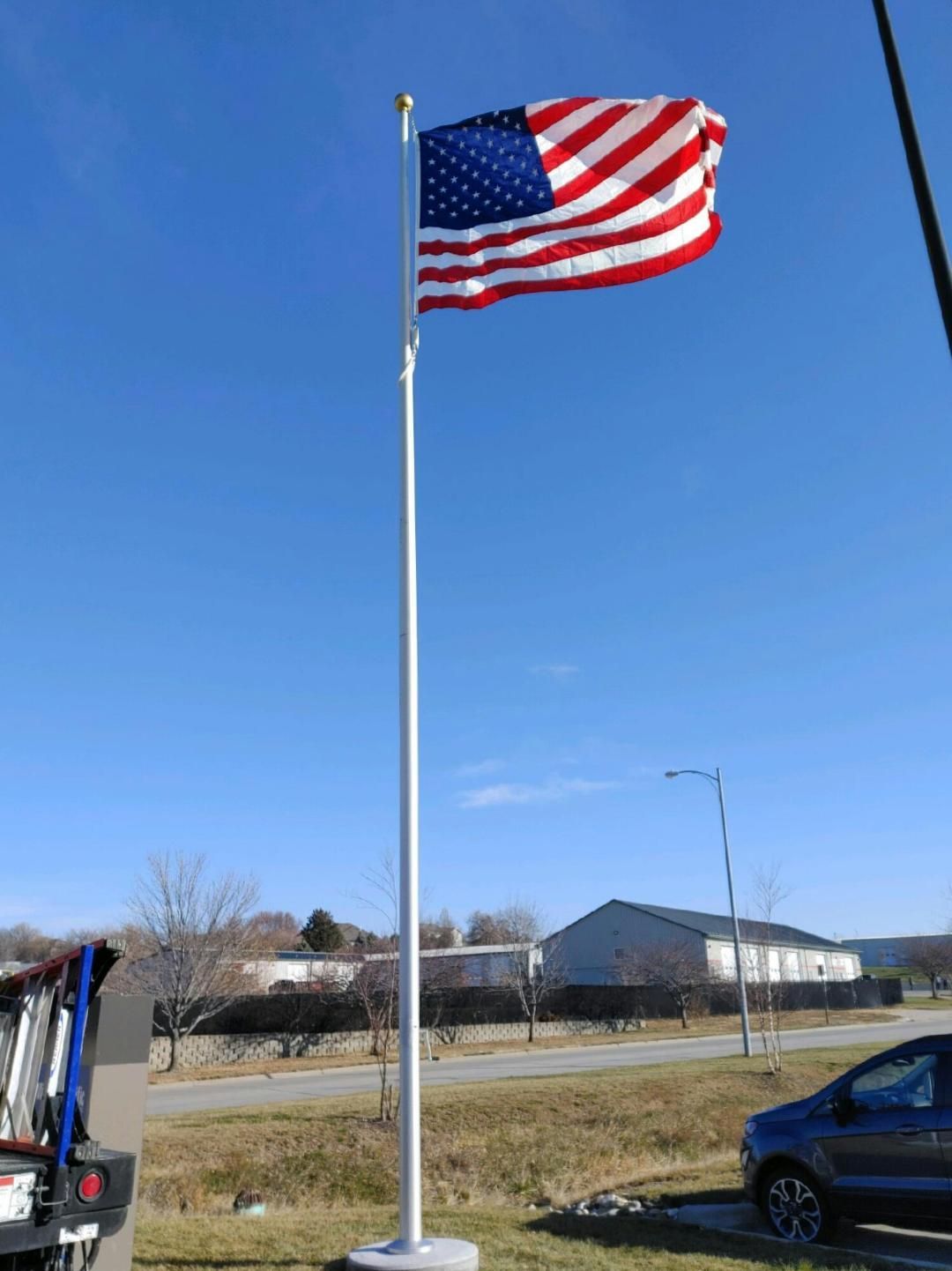 An american flag is flying in the wind on a pole