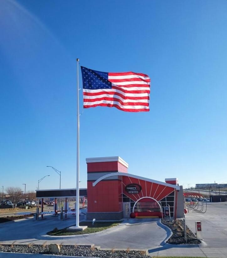 An american flag is flying in front of a red building