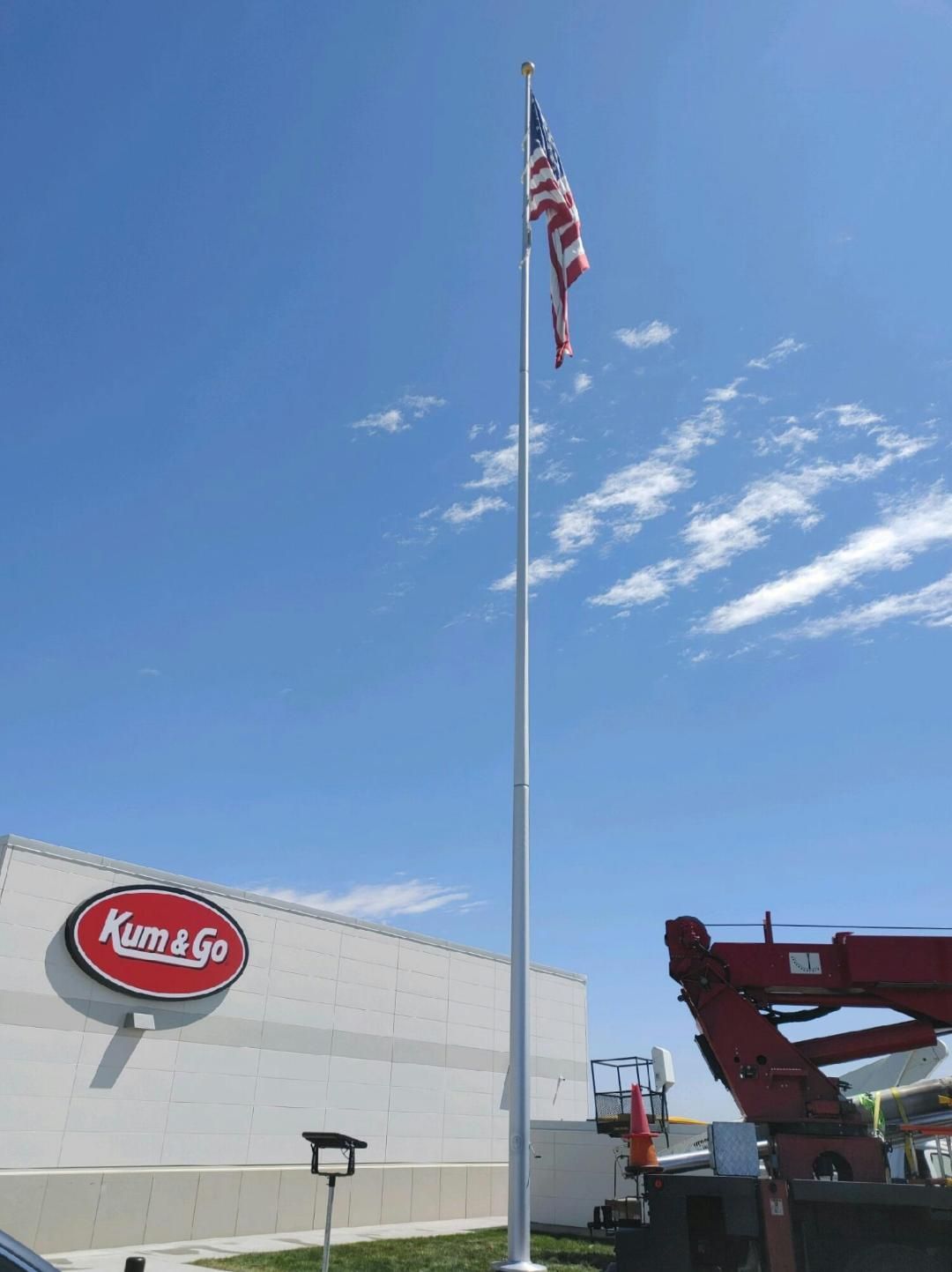 An american flag is flying on a pole in front of a building.