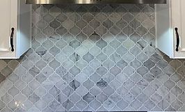 Gray and white patterned tile backsplash in a kitchen.