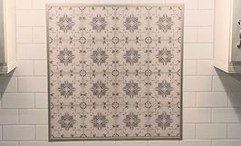 Square tile backsplash with floral pattern centered above white subway tiles.