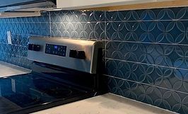 Blue patterned kitchen backsplash above a stainless steel stove.