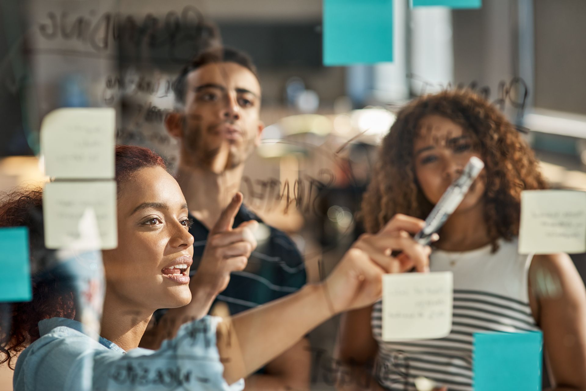 Two people collaborating on a design project at a desk, with color swatches, computer, and drawing tablet.