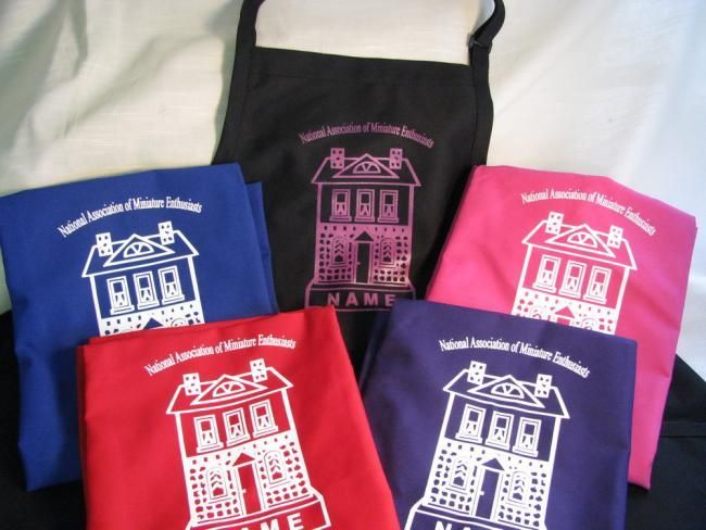Five colorful tote bags with a white house logo and text, arranged on a white surface