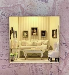 Elegant cream living room with sofa, framed portraits, and soft yellow striped wallpaper
