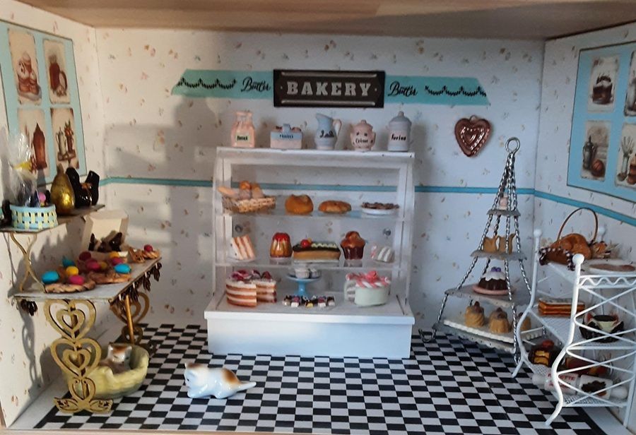 Miniature bakery display with shelves of pastries, checkered floor, and Eiffel Tower decor