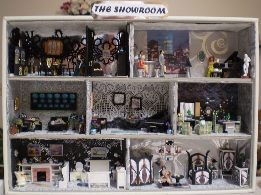 Miniature showroom display with tiny rooms, furniture, and decor arranged on shelves