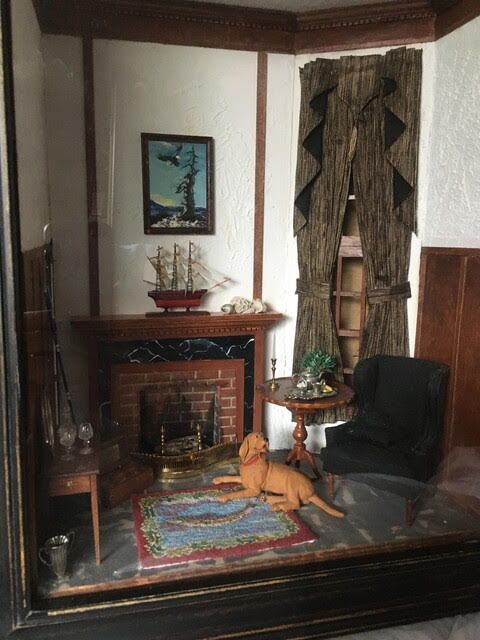 Cozy living room with fireplace, dark chair, patterned rug, and a cat lying in front of the hearth