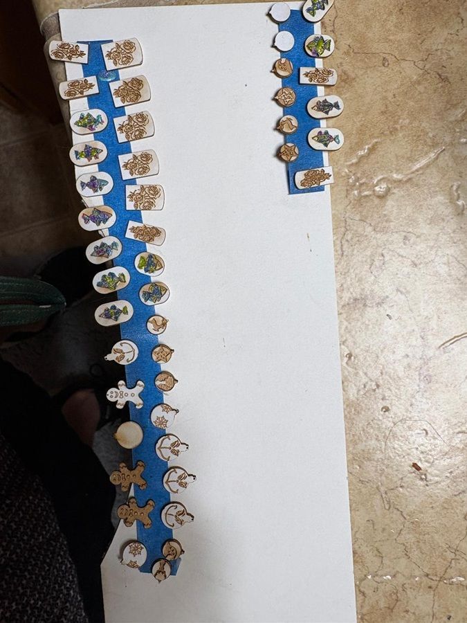 Blue-and-white paper chain craft laid on a table, with small cutout figures and flowers along the edges