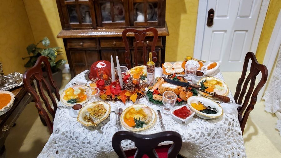 Dining table set with a colorful spread of food and drinks in a warm, home dining room.