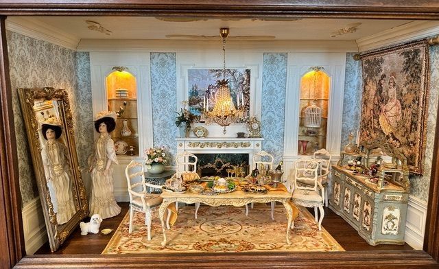 Miniature elegant living room with ornate furniture, fireplace, mirrors, and warm window lights