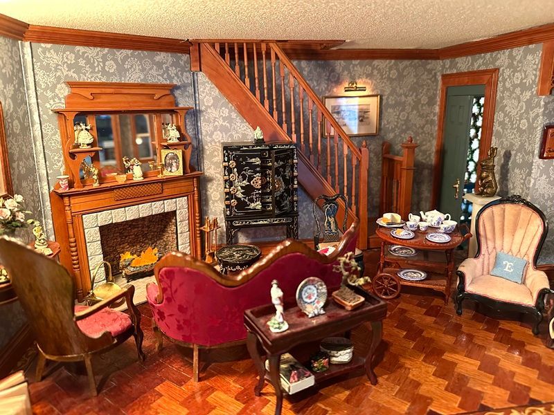 Cozy vintage living room with fireplace, staircase, red armchair, and wood furniture