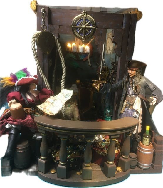 Miniature pirate scene with a captain, treasure chest, lanterns, and ship’s wheel in a small diorama.