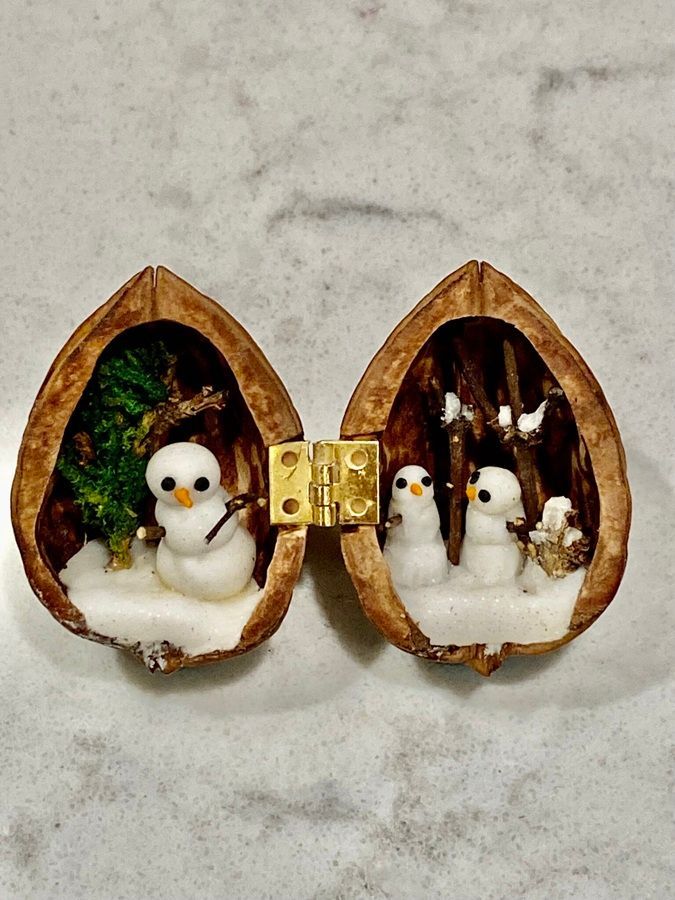 Open wooden egg ornament with a snowman and two chicks in a winter scene