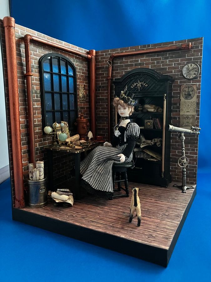 Miniature brick room with a doll seated by a round table, arched window, and dark cabinet.