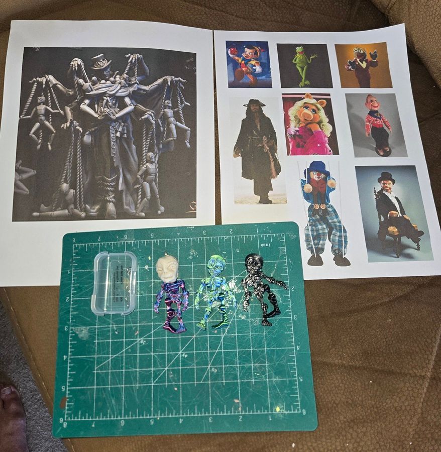 Photos of collectible action figures and character images laid out on a table with a cutting mat.