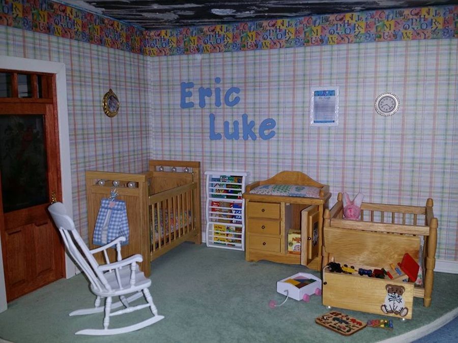 Children's playroom with crib, rocking chair, toys, and wall letters reading "Eric Luke"