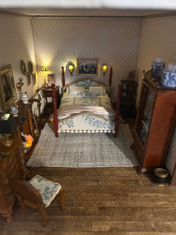 Vintage bedroom with a brass bed, patterned wallpaper, warm lamps, and dark wood furniture