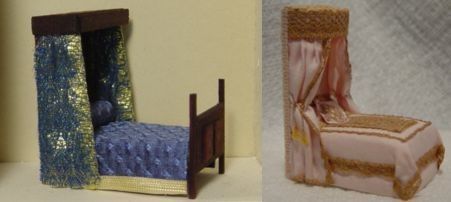 Two miniature canopy beds, one blue and silver, one pink and gold, displayed side by side on a plain background