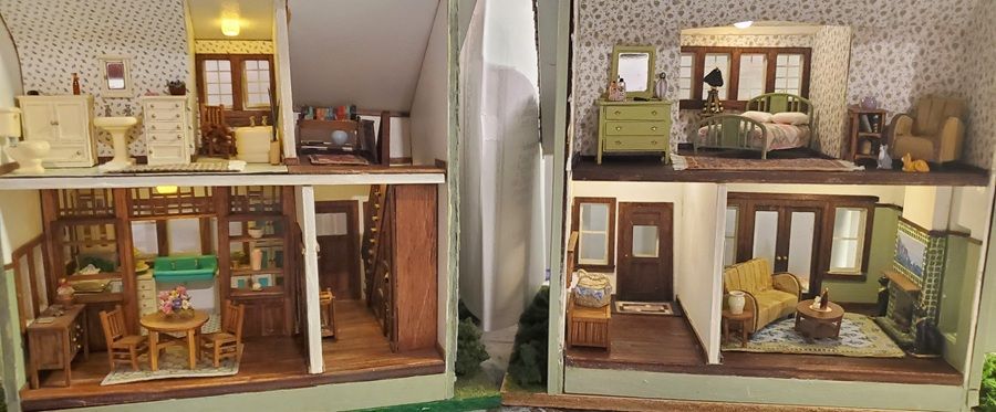 Miniature dollhouse rooms with wood furniture, patterned wallpaper, and warm lighting.