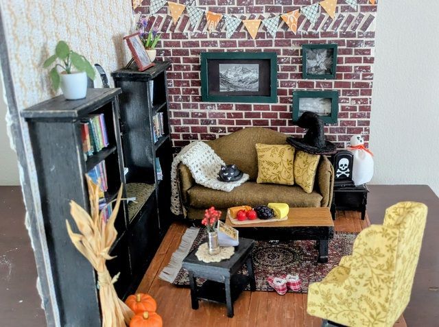 Miniature cozy living room with brick fireplace, sofa, coffee table, and bookshelf on patterned rug