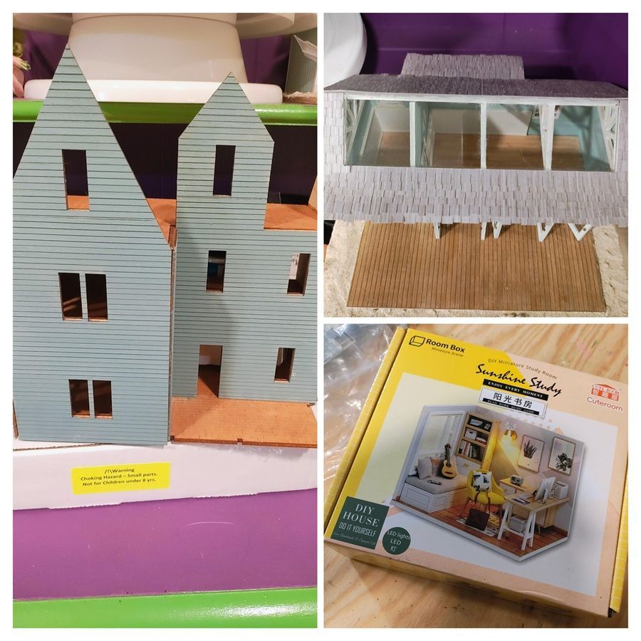 Cardboard model house with gray striped walls and a small box showing the kit on the floor
