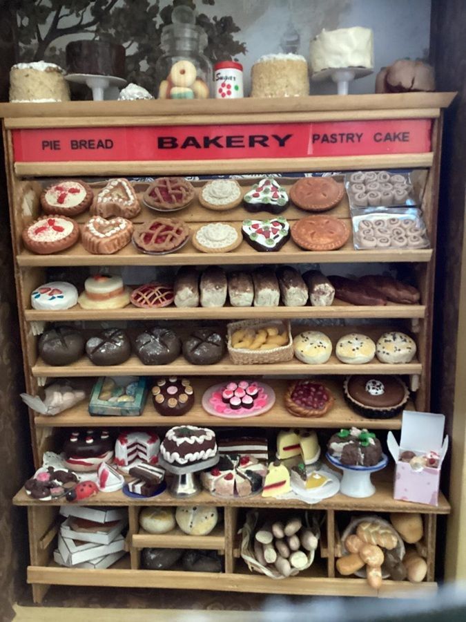 Bakery display shelf with assorted pastries, breads, cakes, and pies in a shop window.