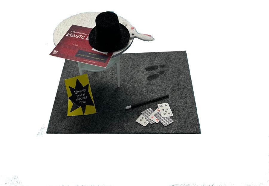 Magic-themed tabletop game pieces on a gray mat, with cards, dice, and a black hat.
