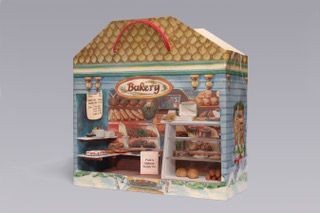 Bakery shop display with shelves of pastries and bread in a small decorative storefront box