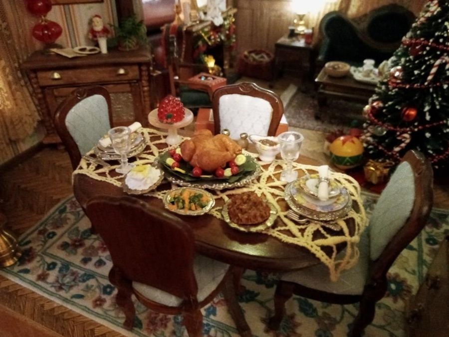 Elegant dining room table set with holiday decorations, roast turkey, and festive tableware